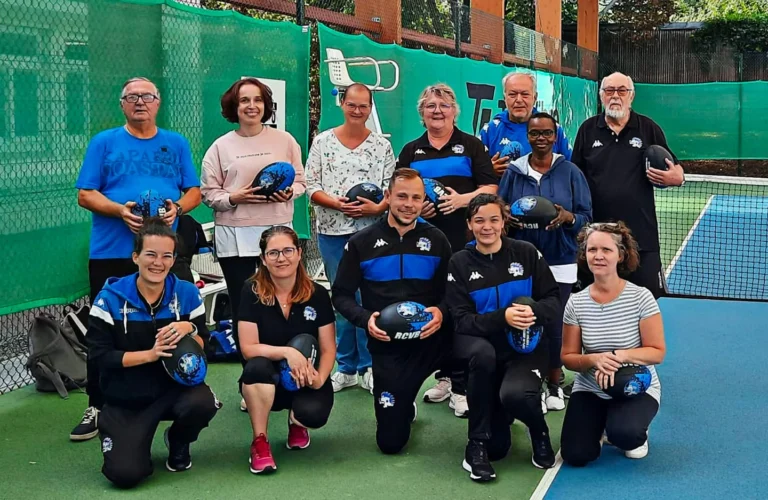 Le groupe des participants de section Rugby Santé de notre rugby club pose pour une photo sur un terrain de sport, chacun tenant un ballon de rugby. Le groupe comprend des hommes et des femmes, certains agenouillés devant et d’autres debout derrière. Certains portent des maillots bleus et noirs avec le logo RCVB. Tout le monde est souriant, exprimant un sentiment de camaraderie et d'esprit d'équipe.
